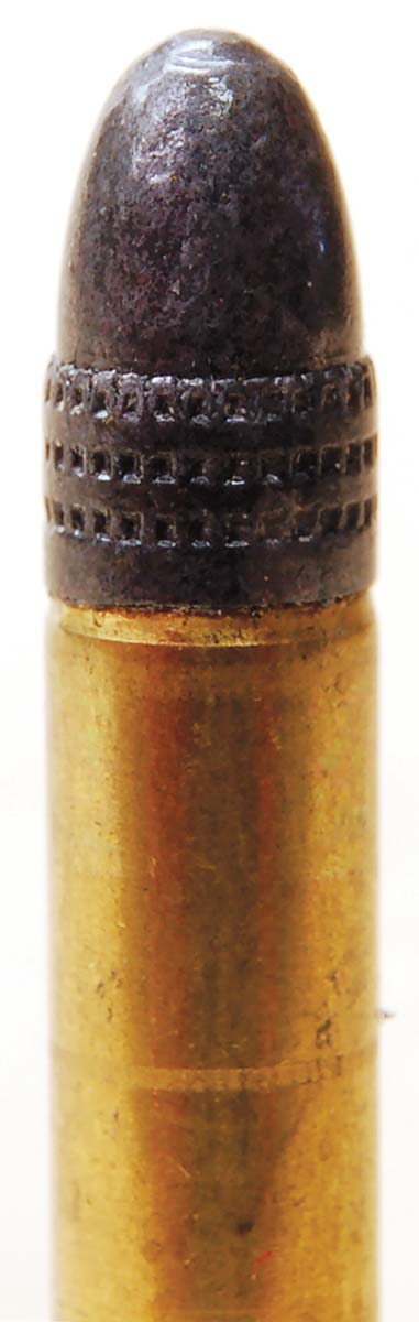Originally, 22 LR bullets were not crimped in cases, but repeating rifles made crimping mandatory. This newer round shows deformation of the case caused by crimping at the base of the bullet.